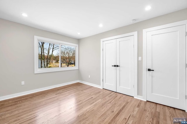 unfurnished bedroom featuring light hardwood / wood-style flooring and a closet