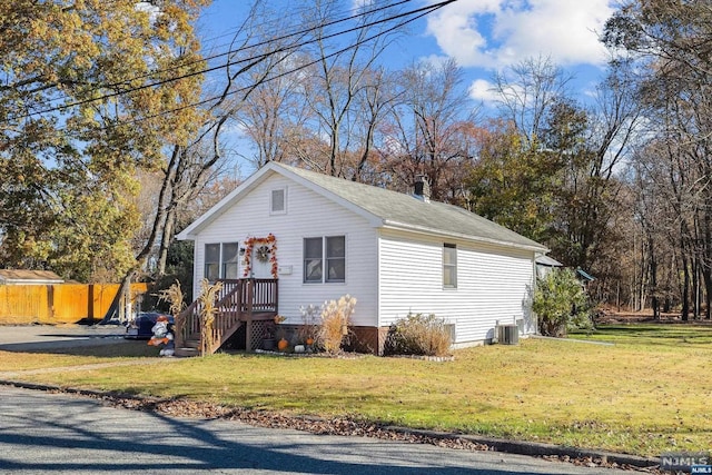 view of front of property featuring central AC unit and a front lawn