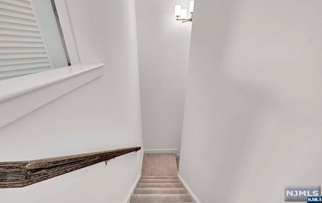 stairway with an inviting chandelier