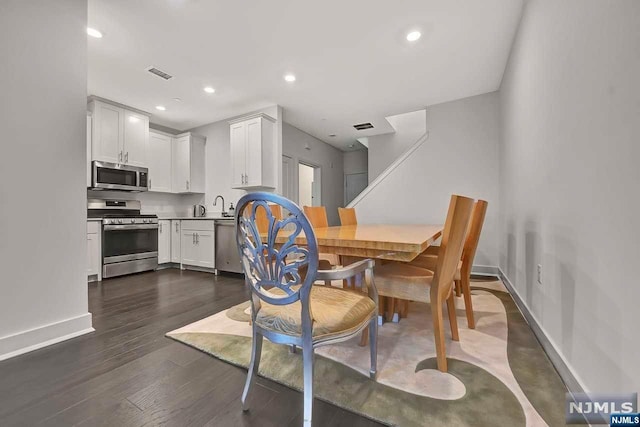 dining space featuring dark hardwood / wood-style flooring and sink