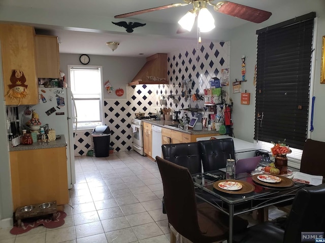 dining space featuring ceiling fan, light tile patterned flooring, and tile walls