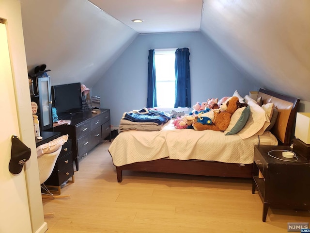 bedroom featuring lofted ceiling and light wood-type flooring