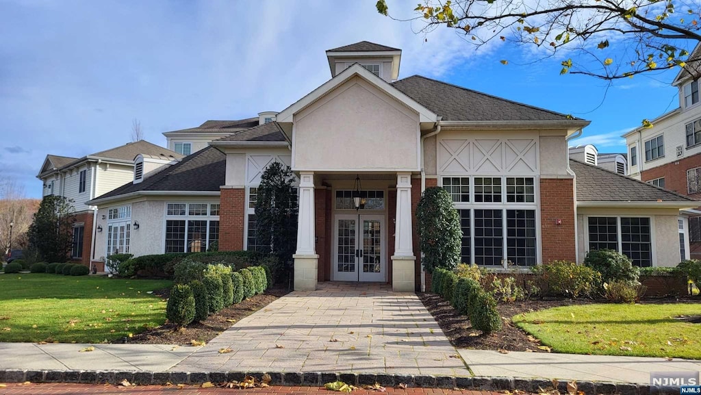 view of front of home featuring french doors and a front lawn