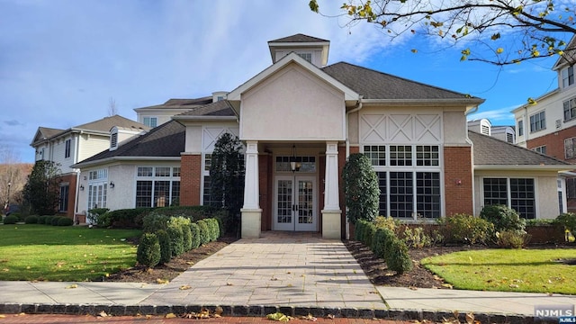 view of front of home featuring french doors and a front lawn