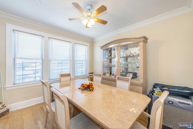 dining space featuring plenty of natural light, ornamental molding, and light hardwood / wood-style flooring