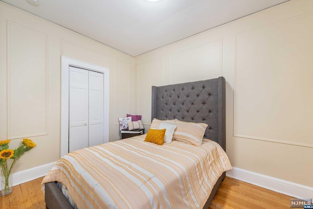 bedroom with wood-type flooring and a closet