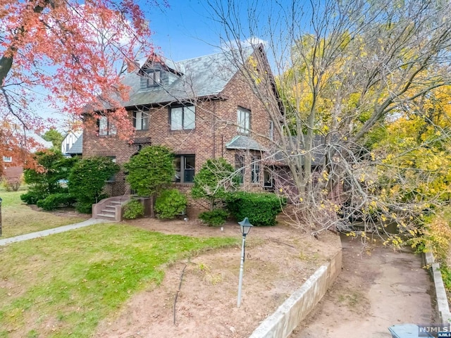 tudor home featuring a front lawn