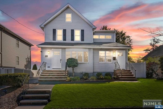 back house at dusk featuring a yard