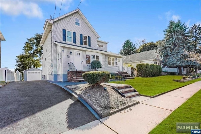 view of front property featuring an outbuilding, a garage, and a front yard