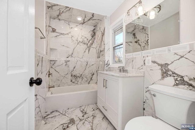 full bathroom featuring vanity, toilet, tile walls, and tiled shower / bath