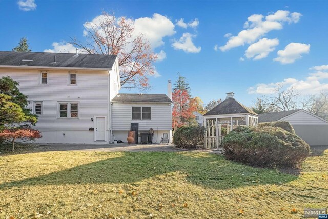 rear view of property with a gazebo and a yard