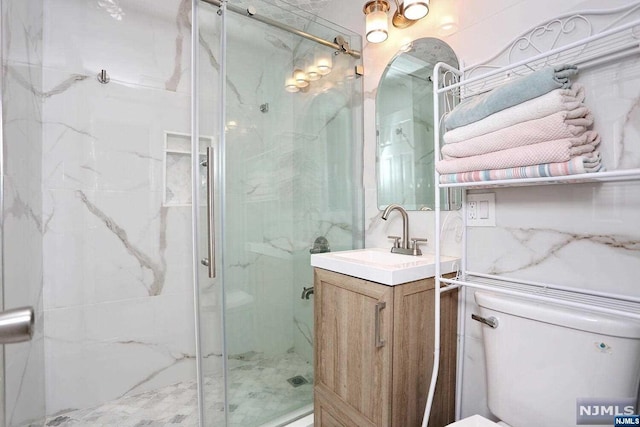 bathroom with toilet, vanity, and walk in shower