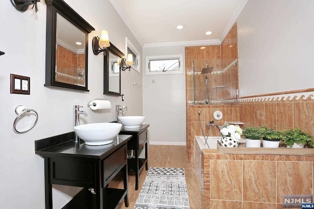 bathroom featuring tile patterned flooring, vanity, a tub to relax in, and crown molding