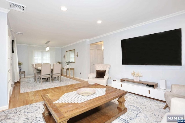 living room with light wood-type flooring and crown molding