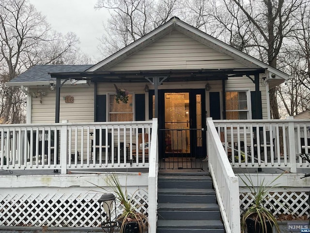 view of front of property featuring roof with shingles and covered porch