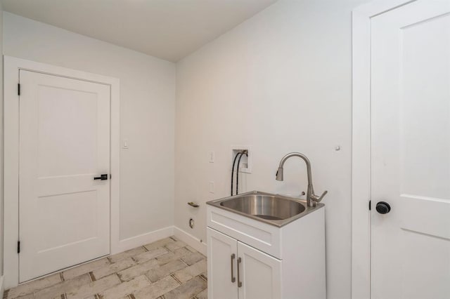 clothes washing area with washer hookup, cabinets, and sink