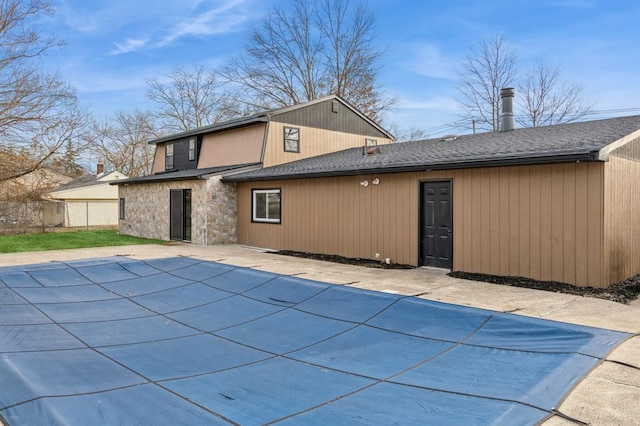 back of house with a covered pool