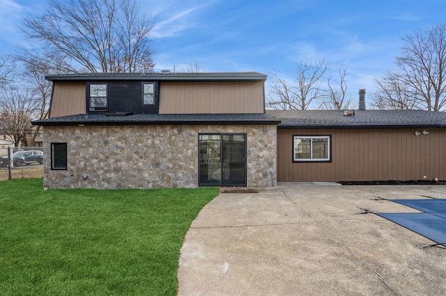 back of property with a lawn, a patio, and a covered pool