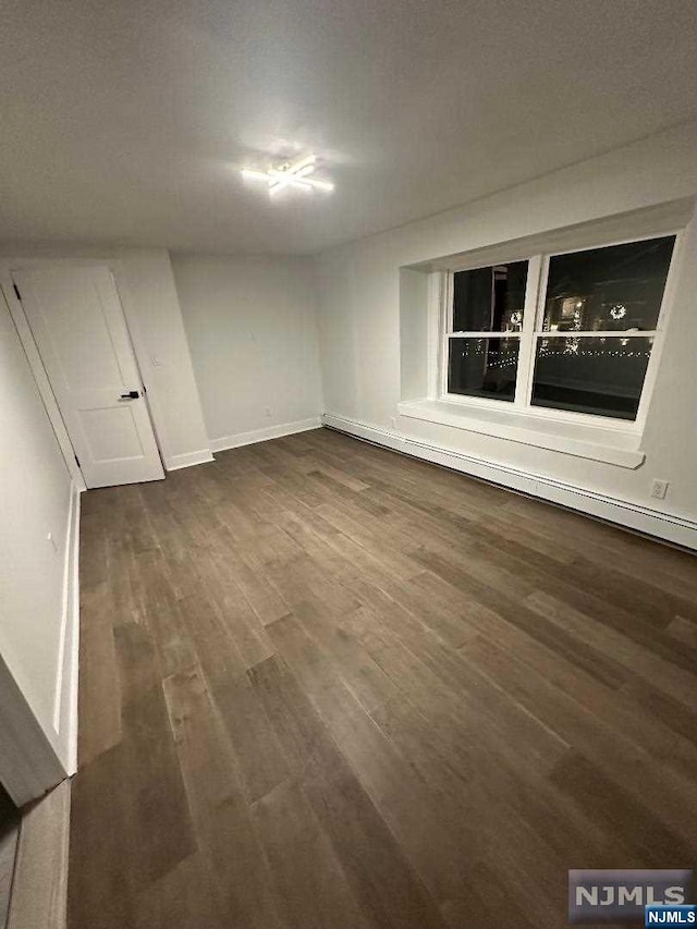 empty room with a textured ceiling and dark wood-type flooring