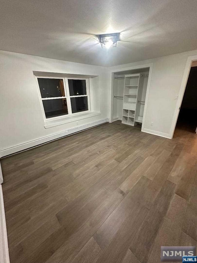 unfurnished bedroom with wood-type flooring, a textured ceiling, and a closet