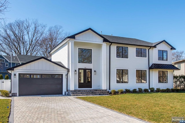 modern inspired farmhouse with a garage, a front yard, and french doors