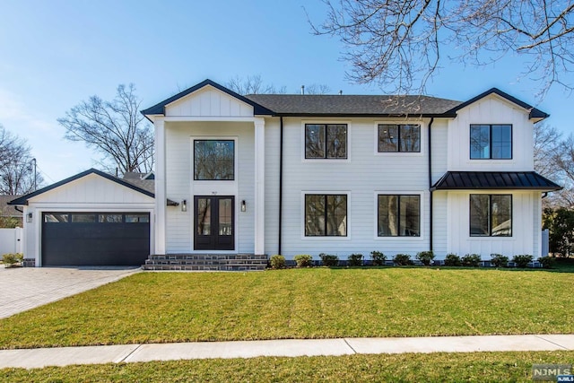 modern farmhouse style home with a garage, a front lawn, and french doors