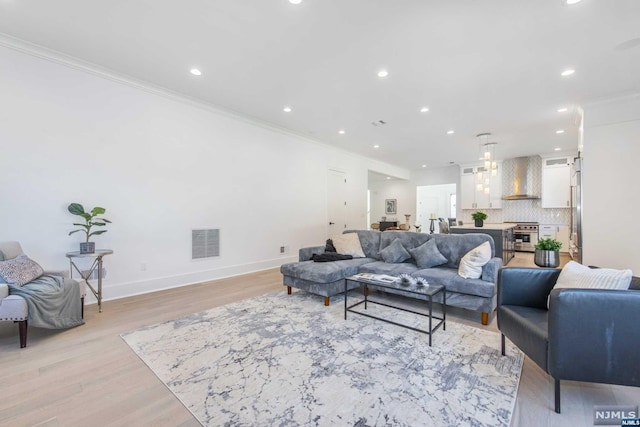 living room featuring light hardwood / wood-style flooring and ornamental molding