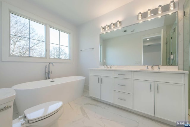 bathroom featuring vanity, a bath, and toilet