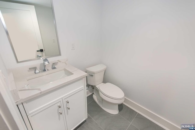 bathroom featuring tile patterned flooring, vanity, and toilet