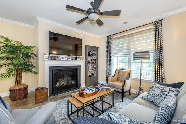 living room with hardwood / wood-style flooring, ceiling fan, and crown molding