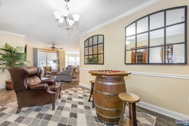 interior space featuring ceiling fan with notable chandelier, hardwood / wood-style flooring, and ornamental molding