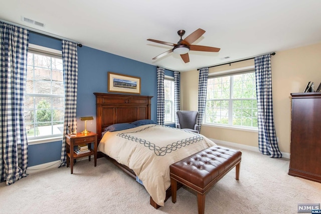 carpeted bedroom with ceiling fan and multiple windows