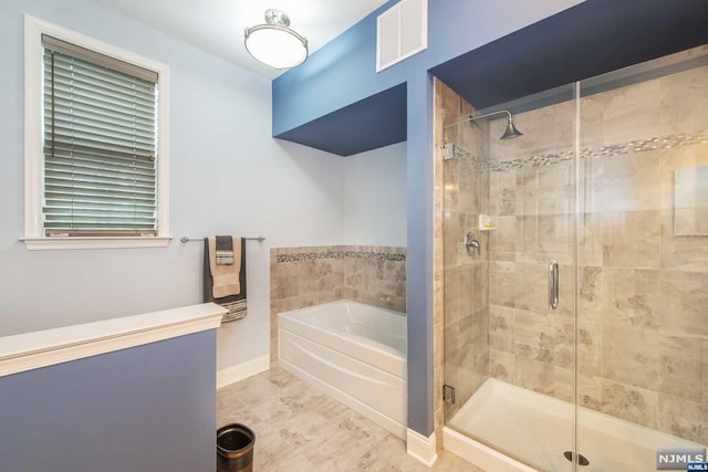 bathroom featuring separate shower and tub