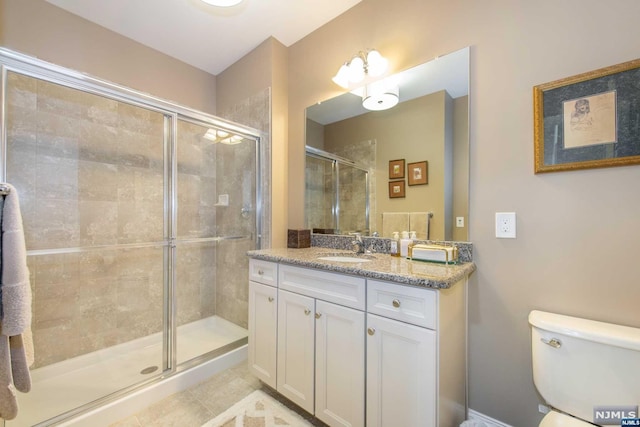 bathroom featuring tile patterned flooring, vanity, and a shower with shower door