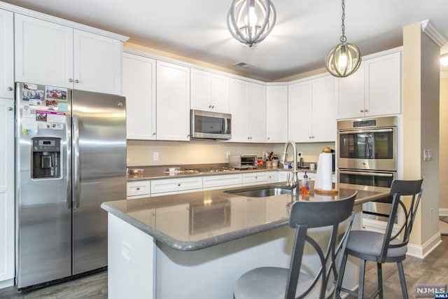 kitchen with white cabinetry, a center island with sink, stainless steel appliances, and sink