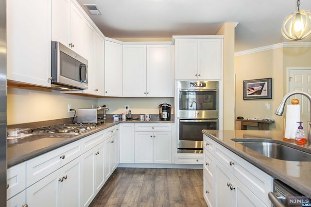 kitchen featuring dark hardwood / wood-style flooring, stainless steel appliances, crown molding, sink, and white cabinetry