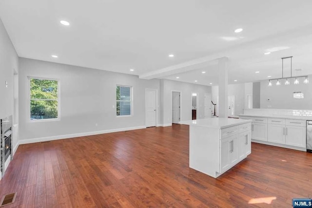 kitchen featuring white cabinets, dark hardwood / wood-style floors, a kitchen island, and plenty of natural light