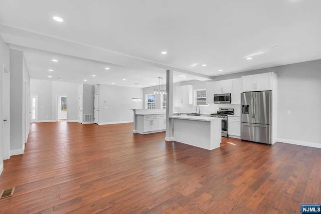 kitchen featuring white cabinets, appliances with stainless steel finishes, dark wood-type flooring, and sink