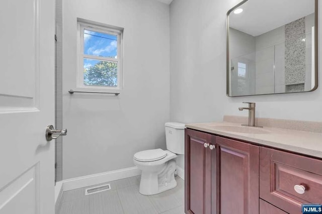 bathroom featuring tile patterned flooring, a shower, vanity, and toilet