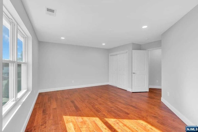 unfurnished bedroom with hardwood / wood-style floors and a closet