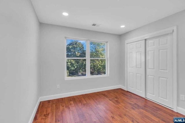 unfurnished bedroom featuring a closet and hardwood / wood-style floors