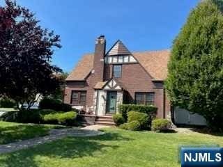 tudor-style house featuring a front yard