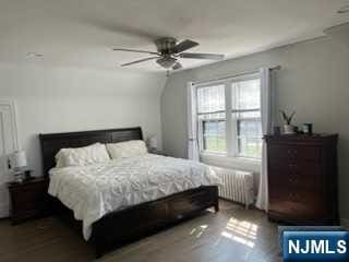 bedroom featuring ceiling fan and radiator heating unit