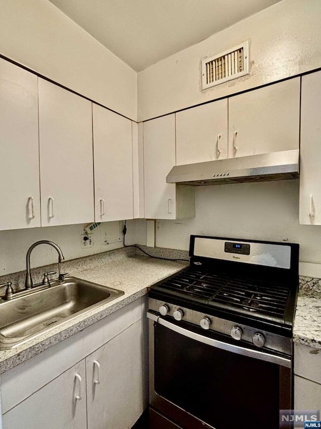 kitchen with white cabinets, stainless steel range with gas cooktop, and sink