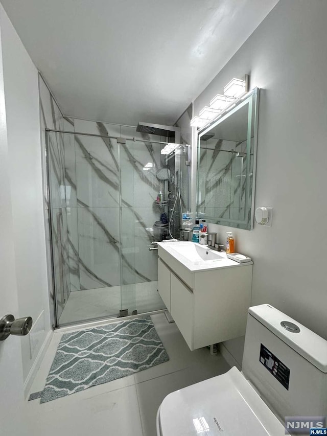 bathroom with tile patterned floors, vanity, toilet, and an enclosed shower