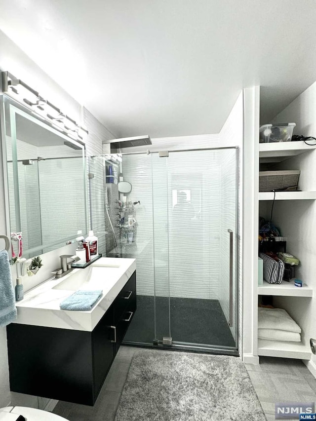 bathroom featuring tile patterned flooring, vanity, and a shower with shower door