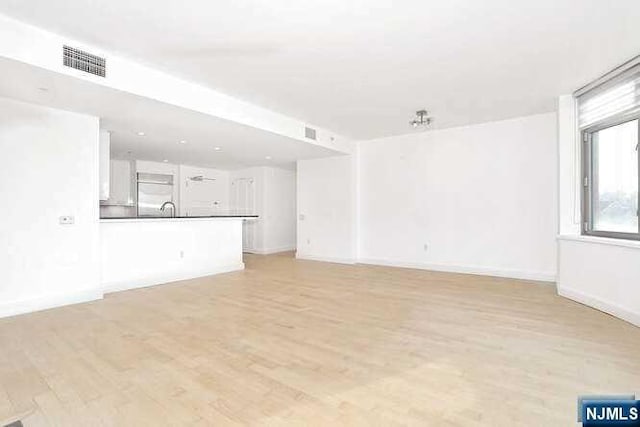 unfurnished living room featuring light wood-type flooring