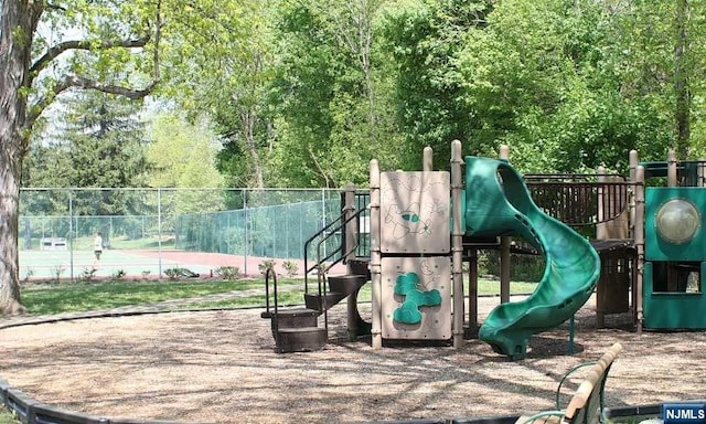 view of jungle gym featuring tennis court