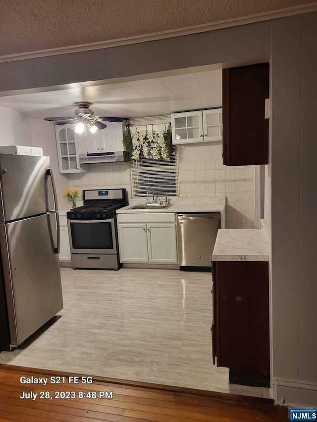 kitchen featuring white cabinets, decorative backsplash, and stainless steel appliances