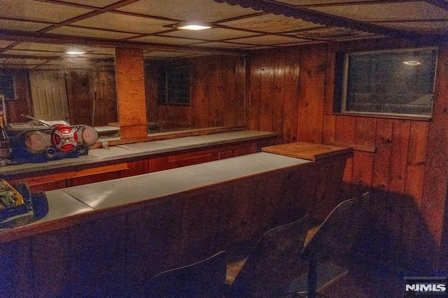 bar with tile countertops and wooden walls